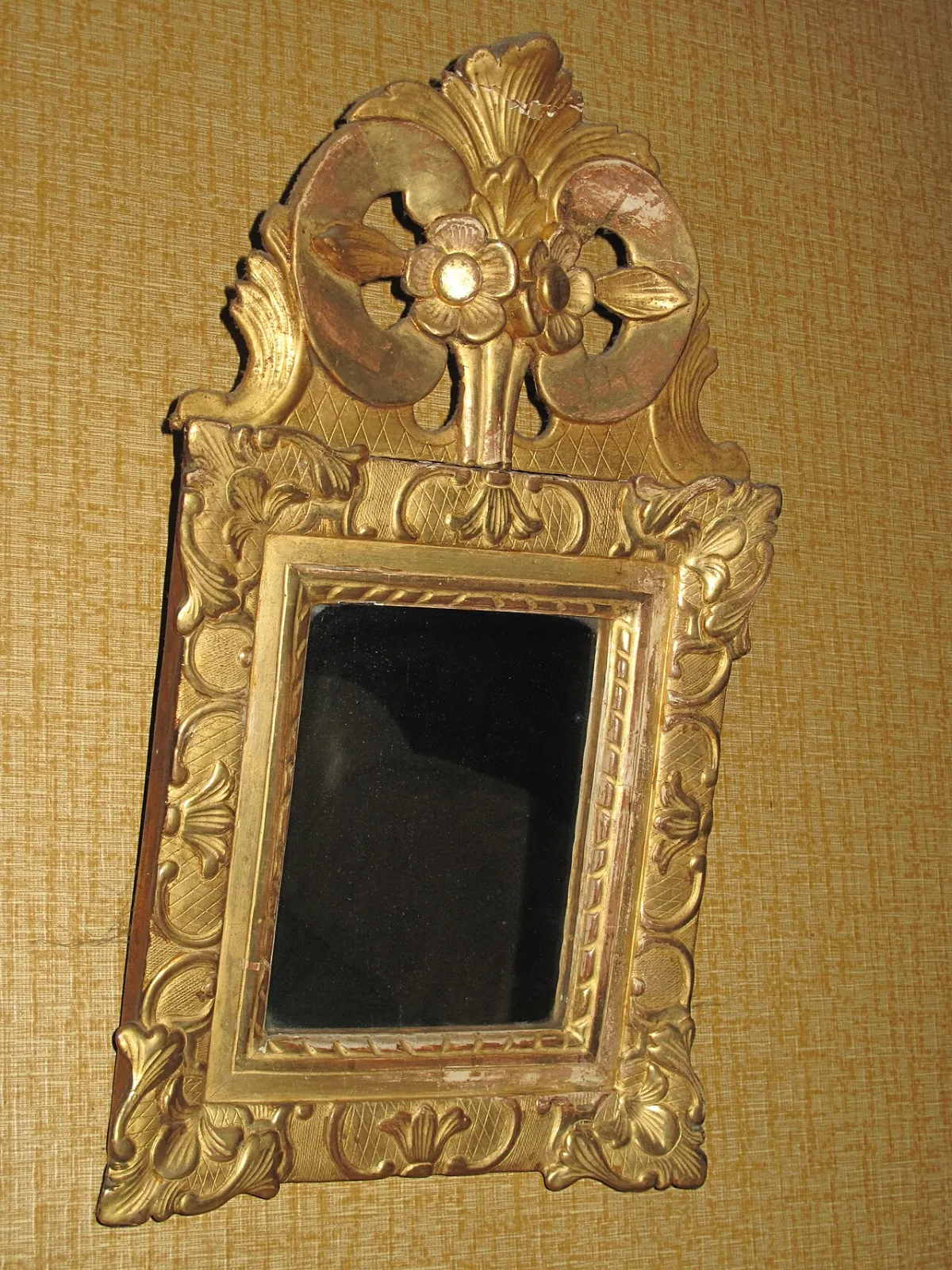 Antieke gouden spiegellijst met sierlijk gesneden ornamenten en bloemmotieven